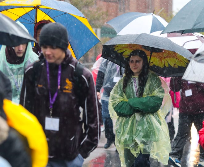Participants with the Catholic Diocese of Wilmington's Catholic Youth Ministry cross pilgrimage head for St. Anthony of Padua in a steady rain as the procession moves between parishes in the nearly day-long event, Saturday, March 23, 2024.