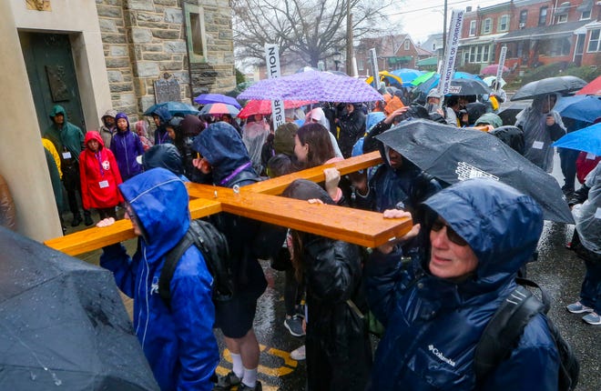 The pilgrimage cross is at the head of the Catholic Diocese of Wilmington's Catholic Youth Ministry cross pilgrimage as it pauses before entering St. Anthony of Padua, Saturday, March 23, 2024.